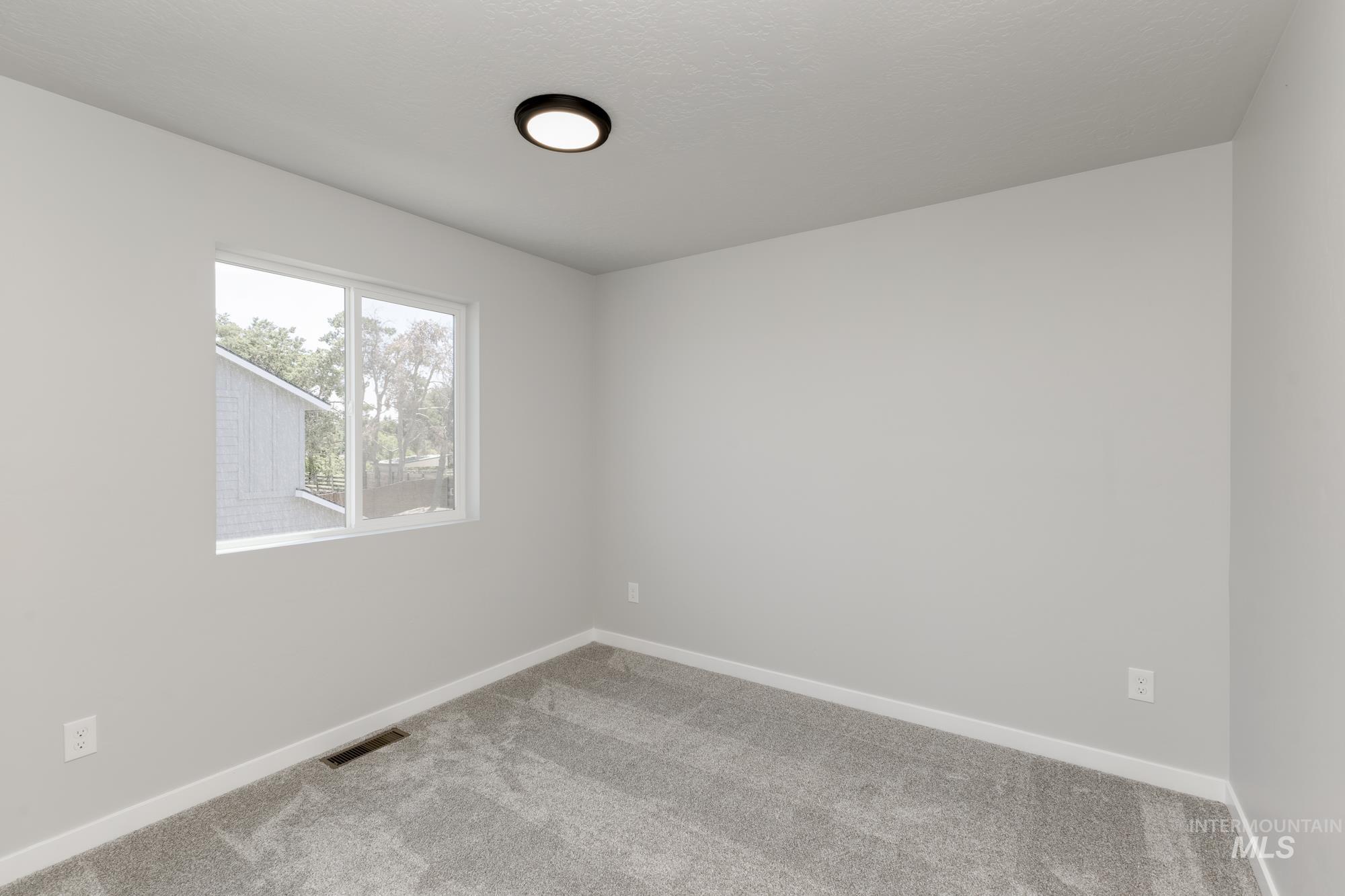 Spare room featuring carpet floors and baseboards