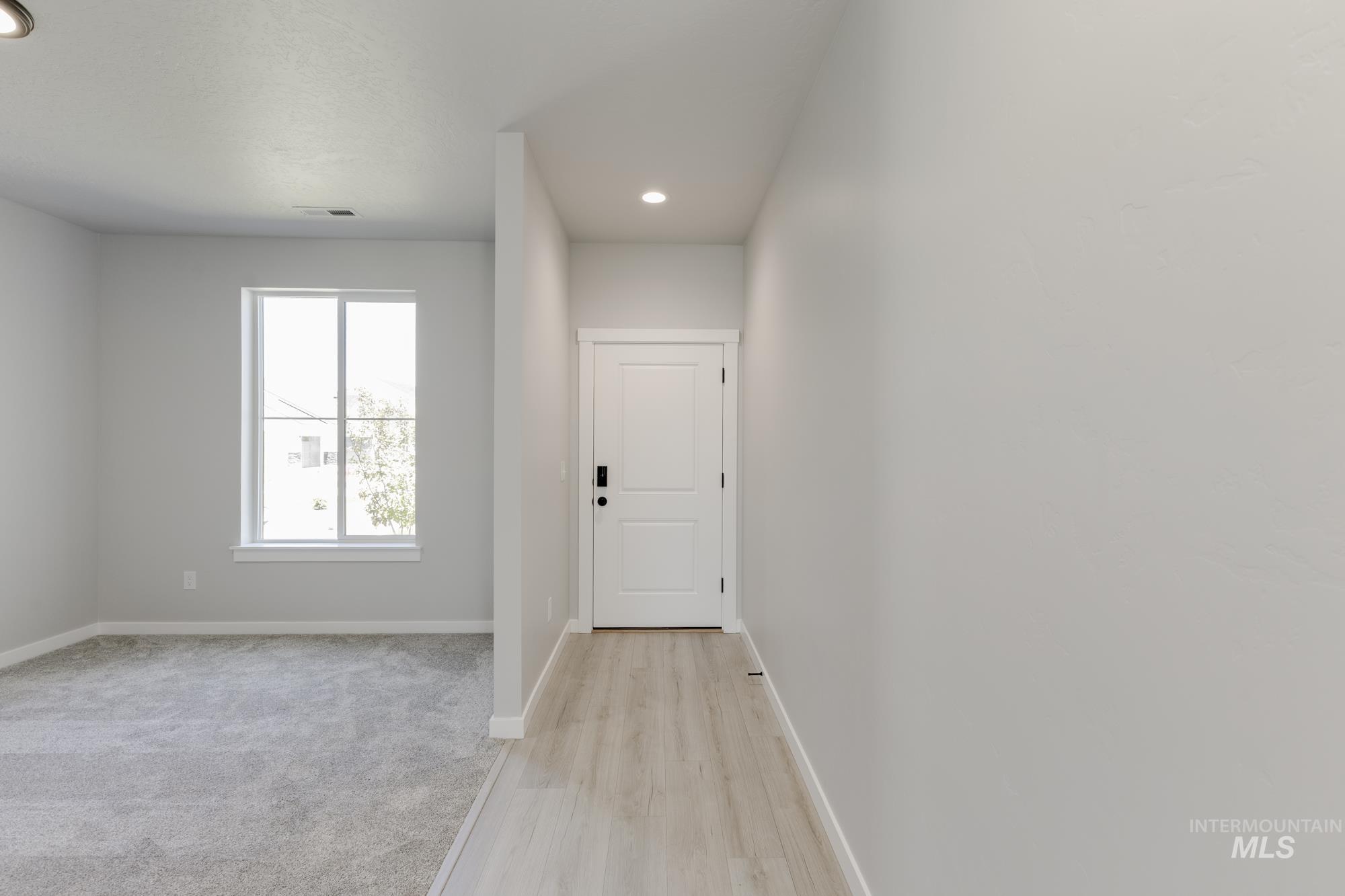 Doorway with light wood-type flooring and recessed lighting