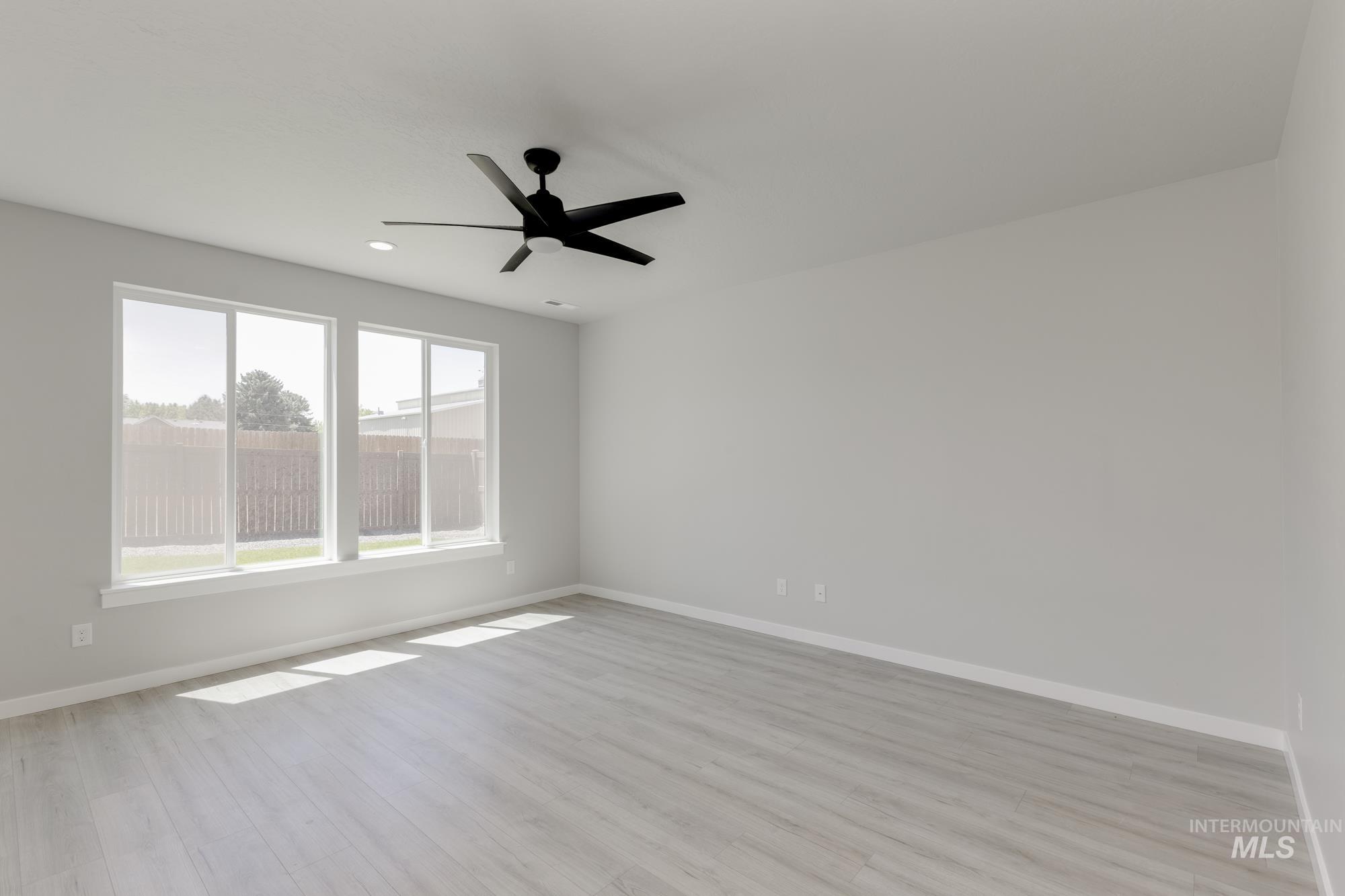Spare room with light wood finished floors, ceiling fan, and recessed lighting