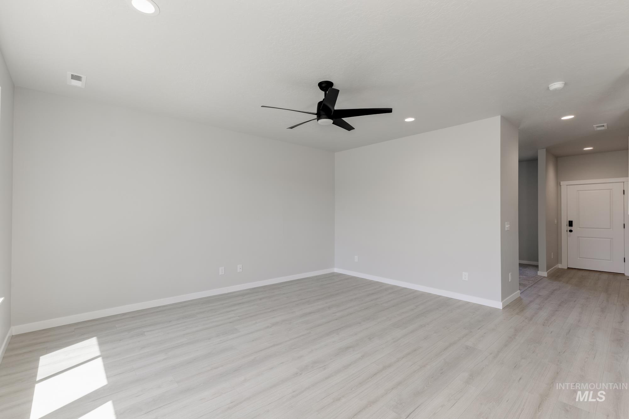 Unfurnished room featuring recessed lighting, a ceiling fan, light wood-style flooring, and a smoke detector