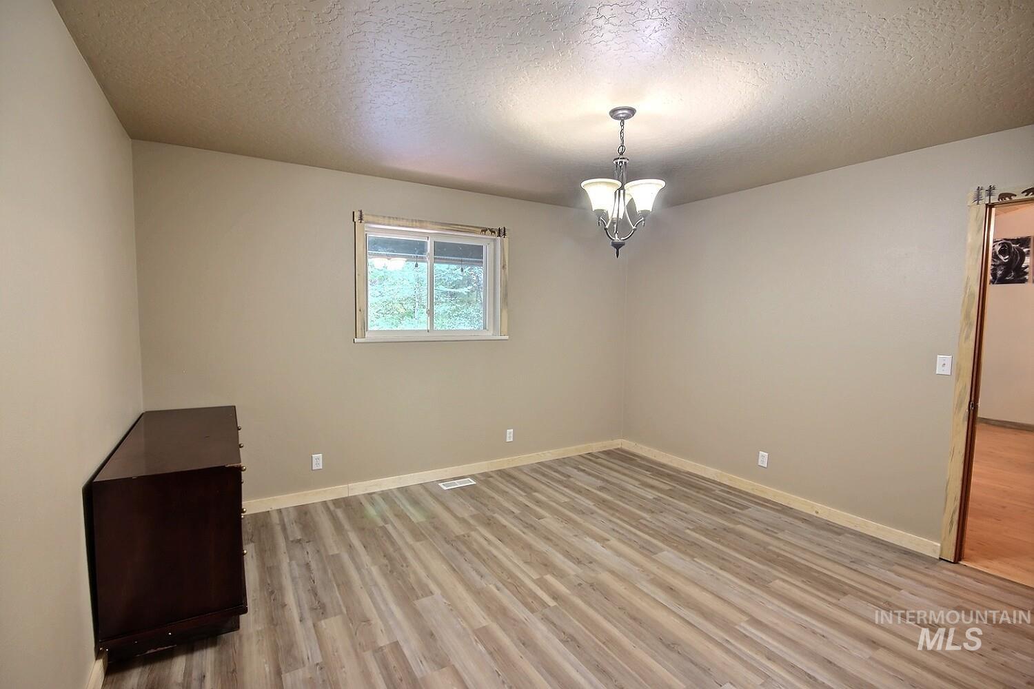 Unfurnished room featuring a textured ceiling and light wood finished floors