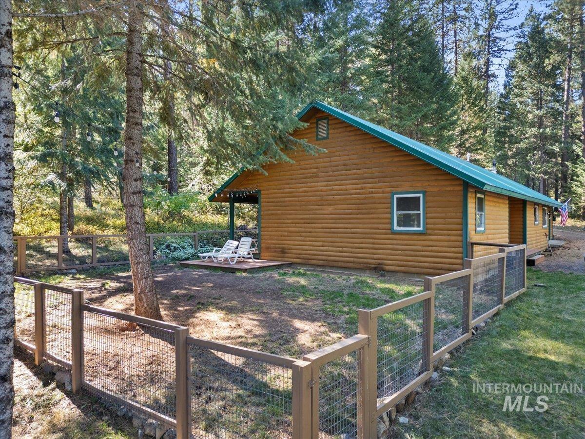 View of home's exterior with log veneer siding and a view of trees