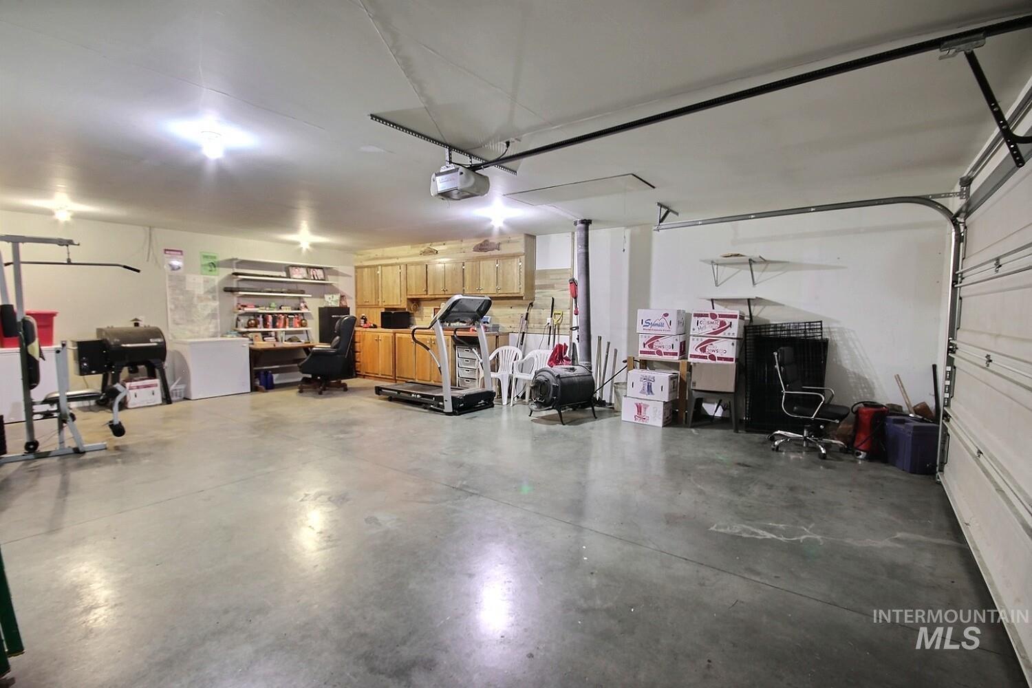 Garage with a garage door opener and white fridge