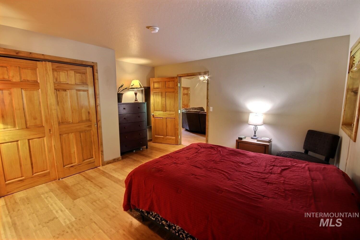 Bedroom featuring light wood finished floors, a closet, and a textured ceiling
