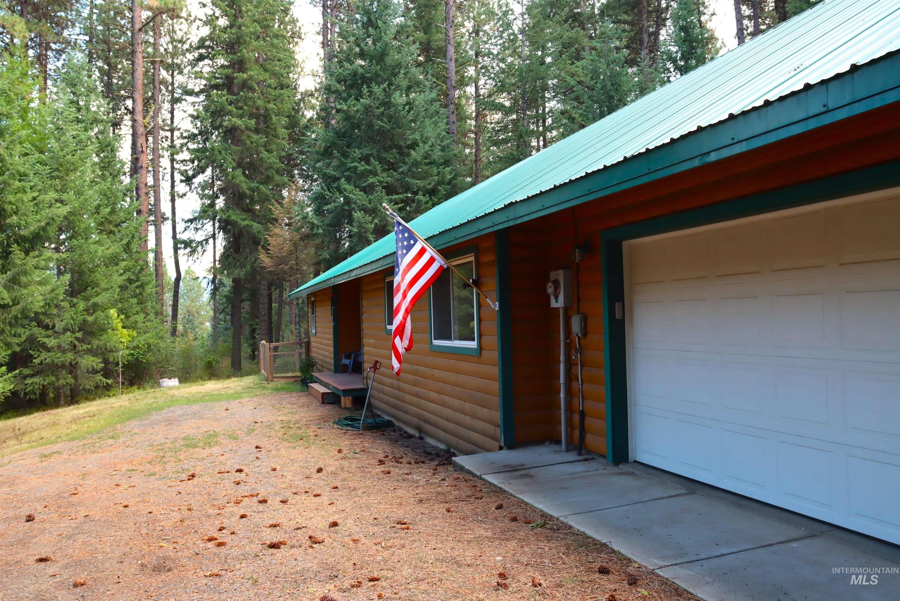 View of home's exterior with a garage, faux log siding, and a metal roof