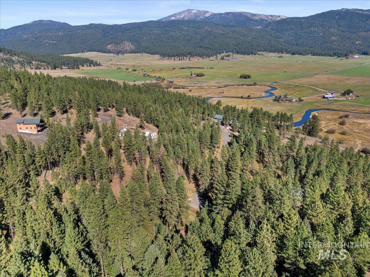 Aerial view of property's location with mountains and a heavily wooded area