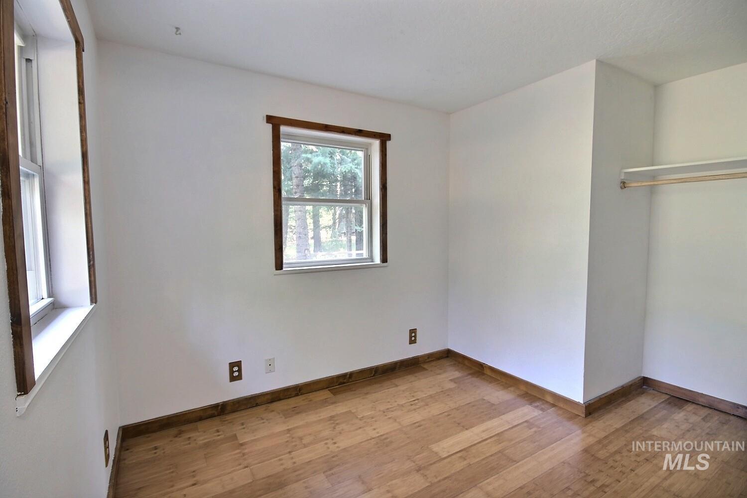 Unfurnished bedroom featuring wood-type flooring and baseboards