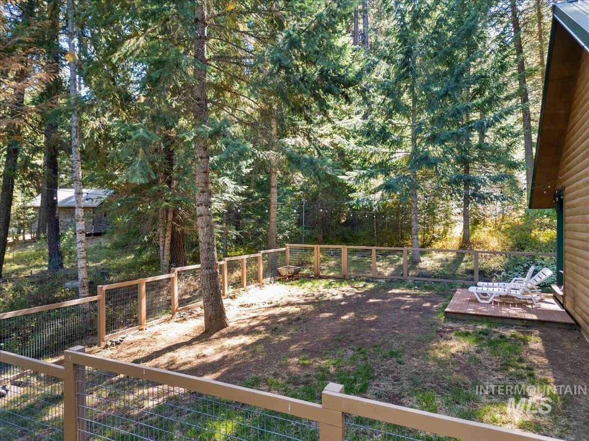 Fenced backyard with a forest view