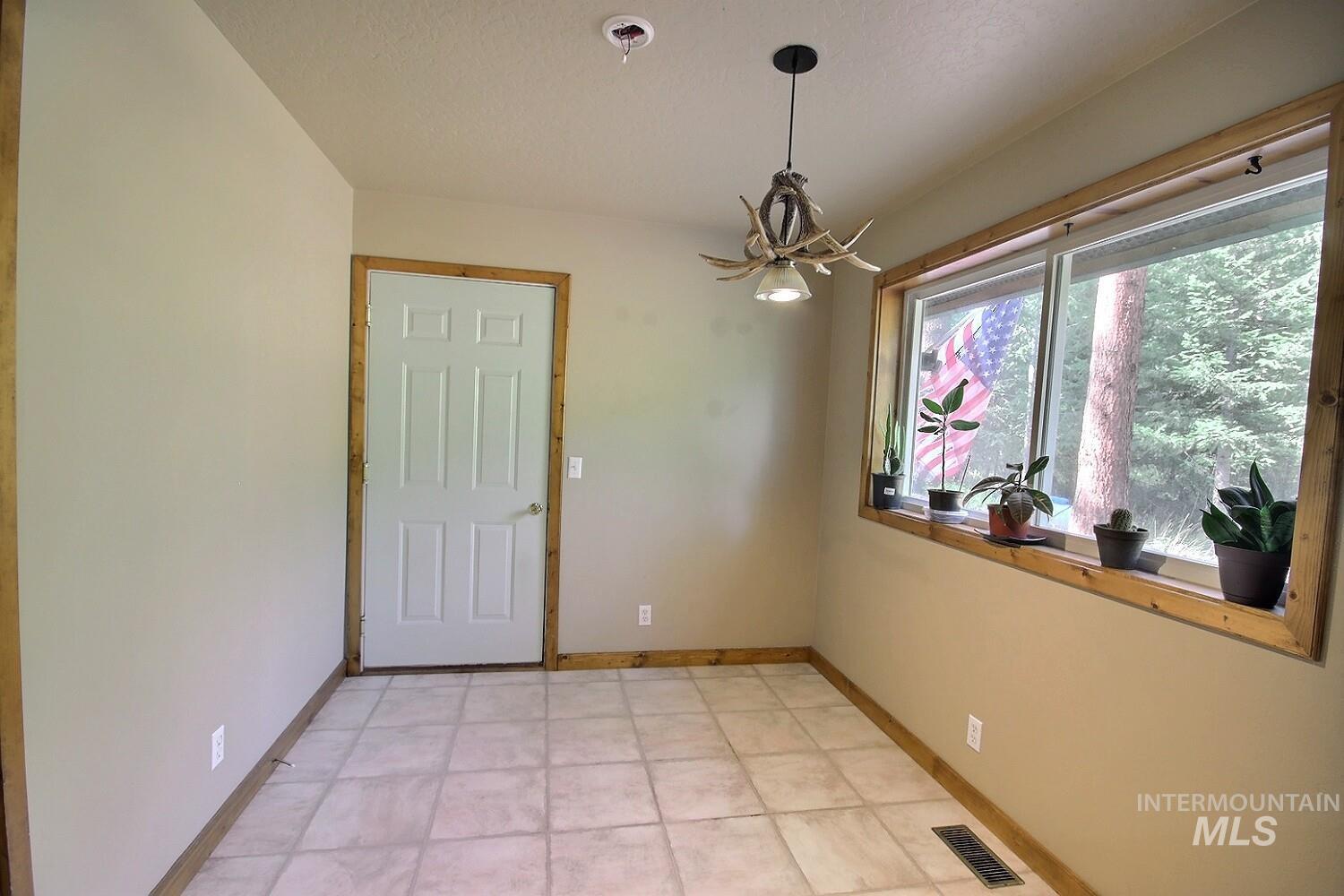 Unfurnished dining area with baseboards and a chandelier