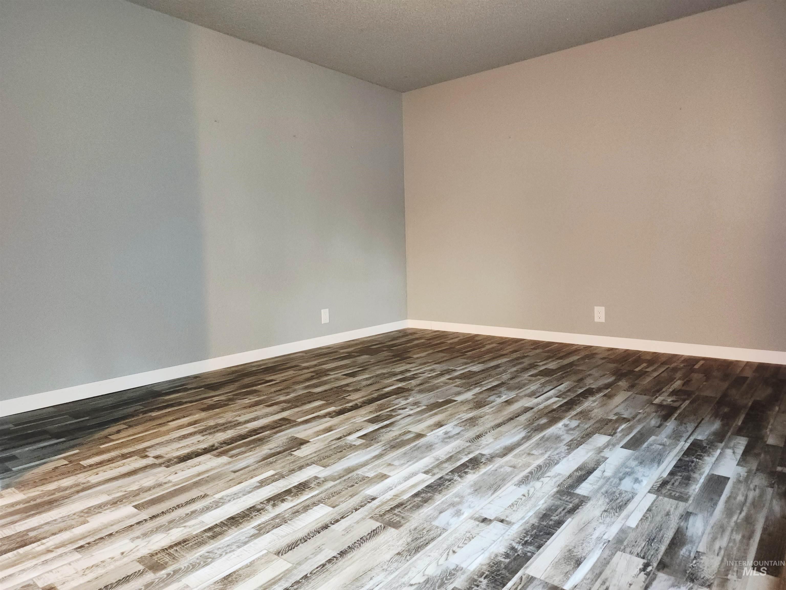 Spare room featuring wood finished floors and a textured ceiling