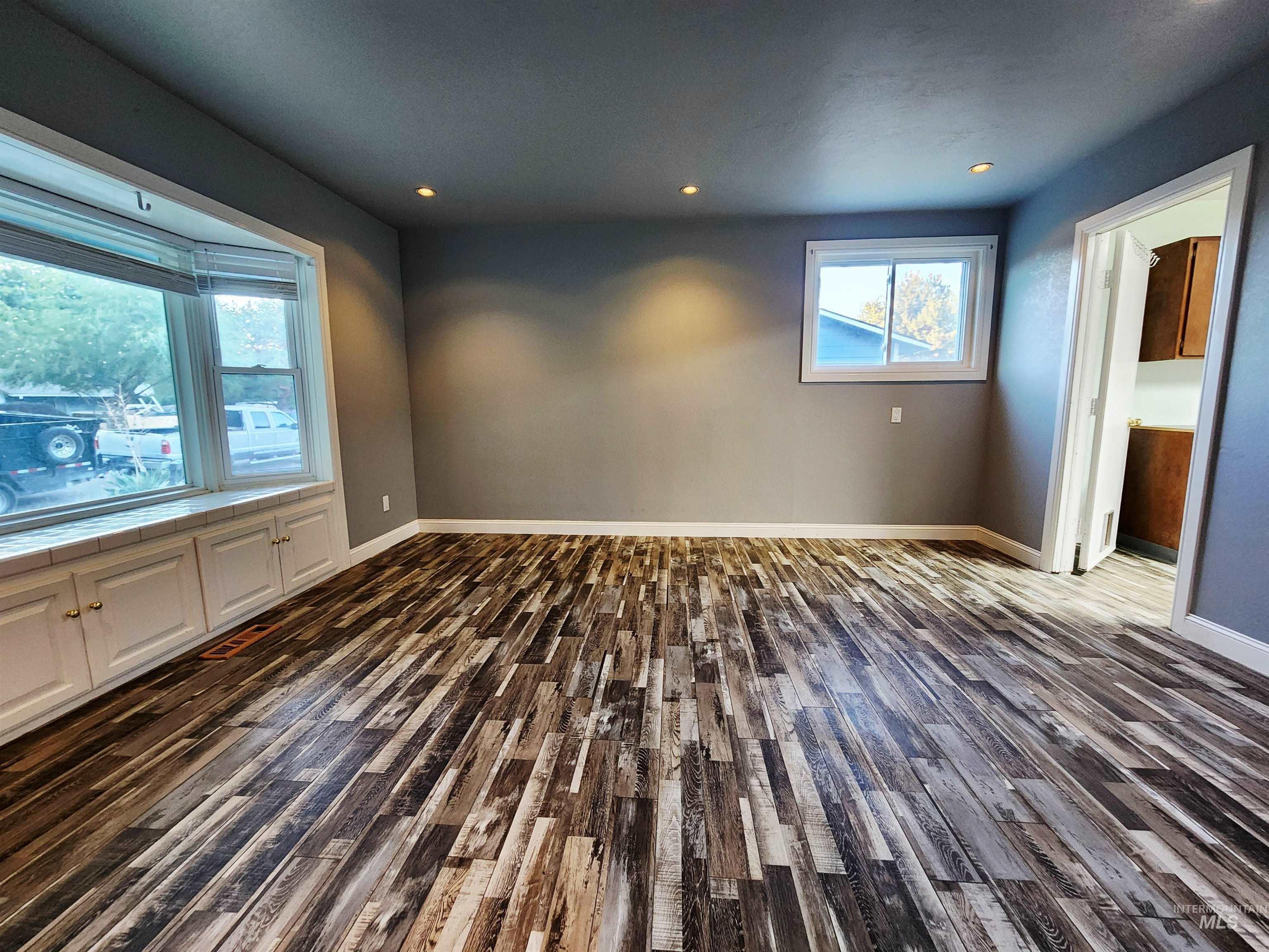 Unfurnished room featuring dark wood-style flooring and recessed lighting