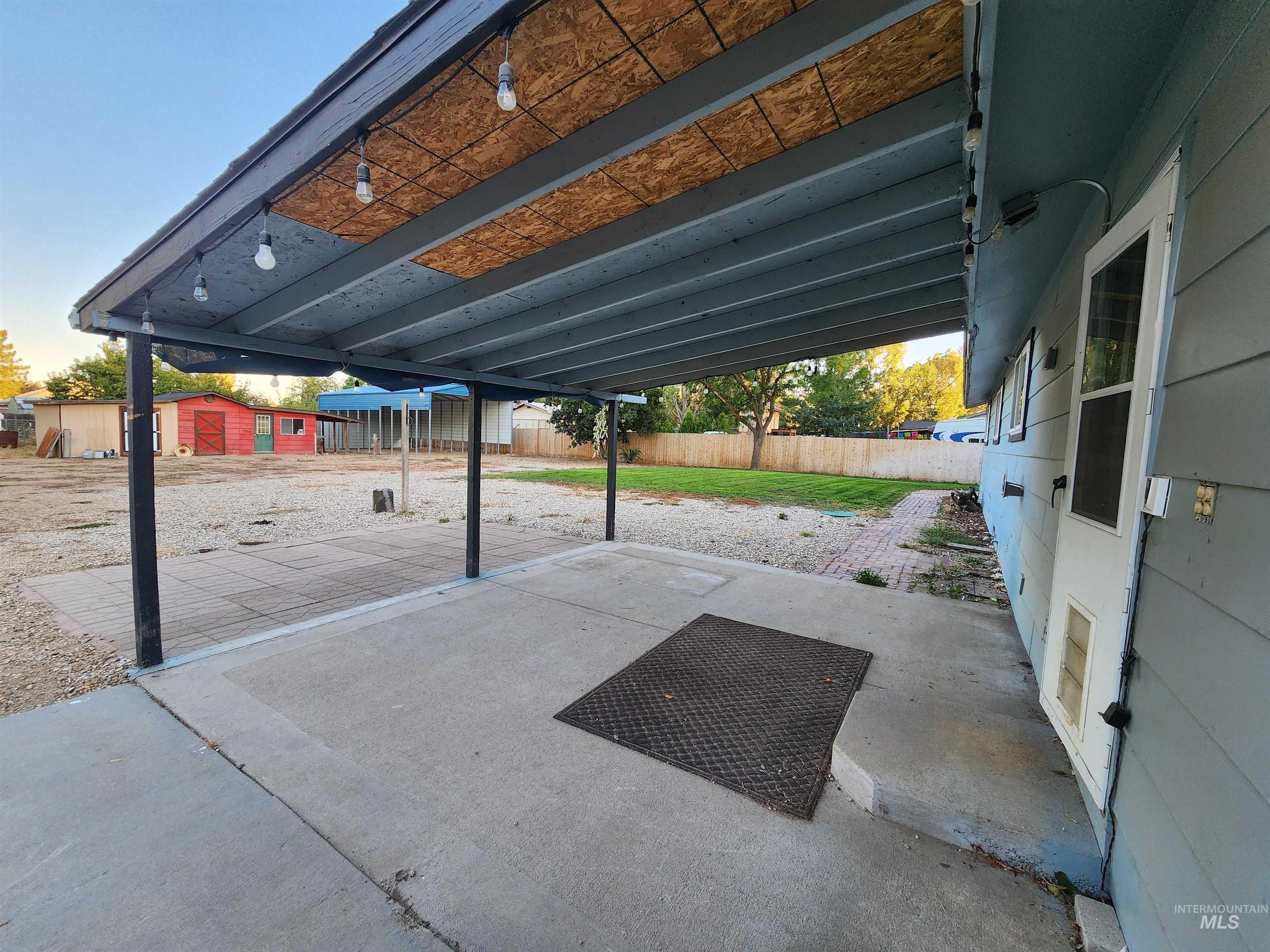 Fenced backyard featuring a patio and a shed