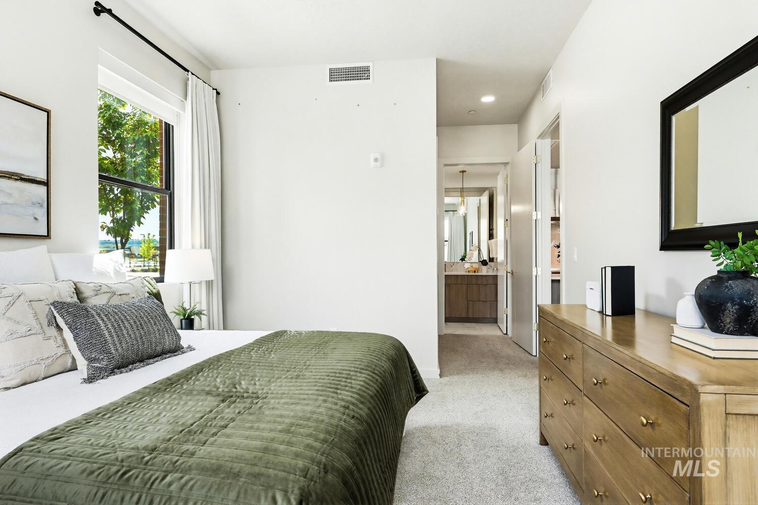 Bedroom featuring connected bathroom, light carpet, and recessed lighting