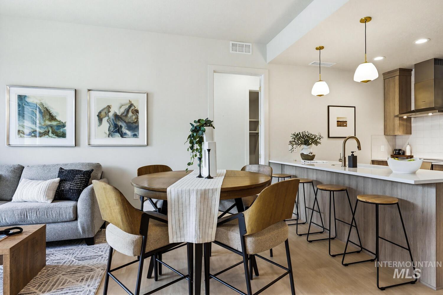 Dining area with light wood-style floors and recessed lighting