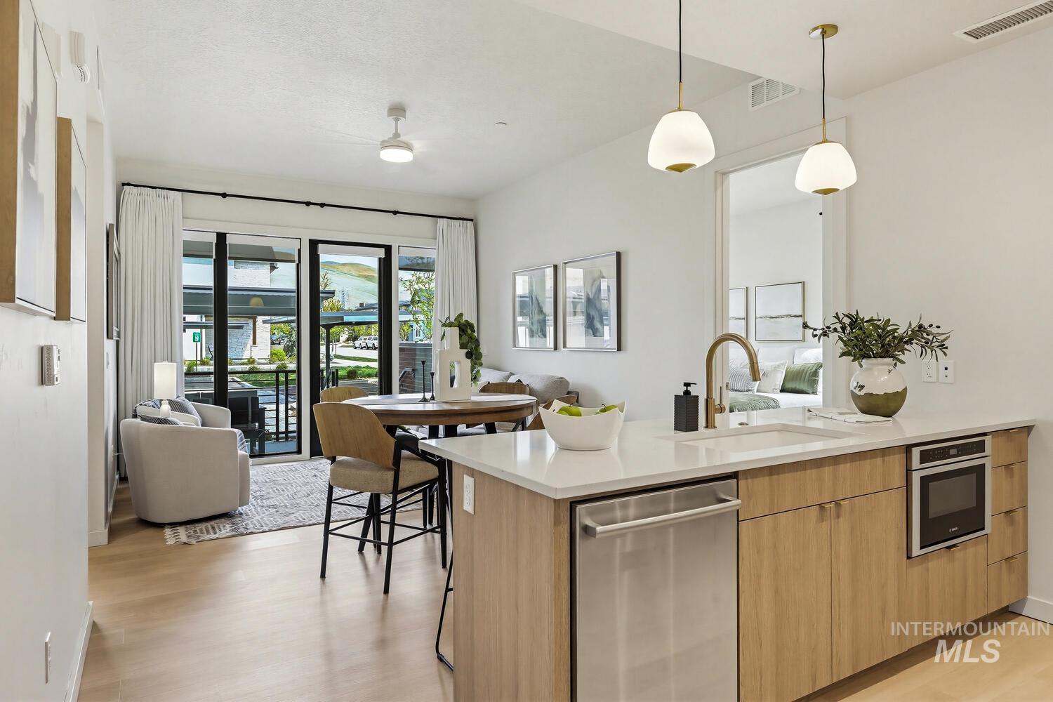 Kitchen featuring a peninsula, open floor plan, stainless steel appliances, and light wood-style floors