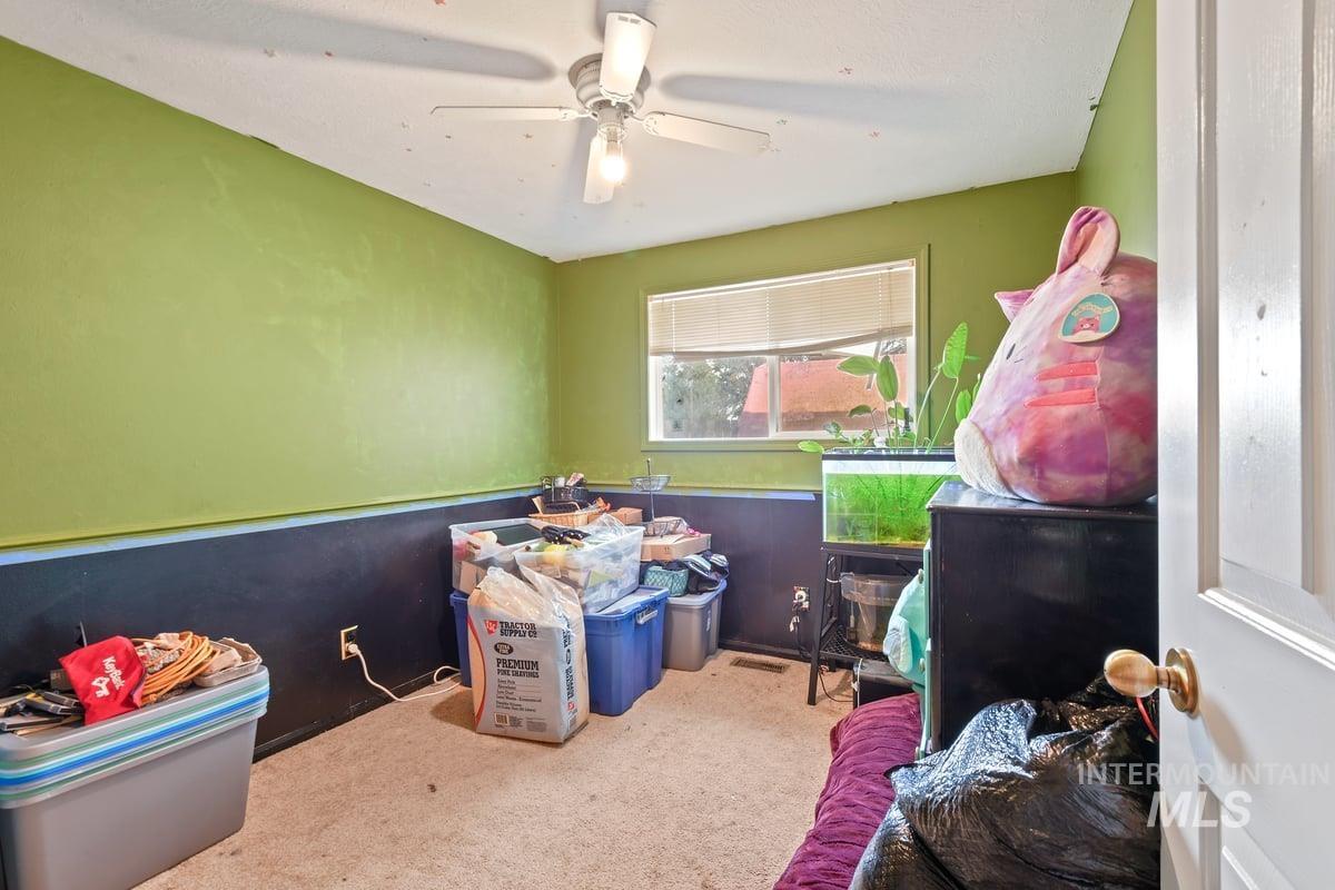 Recreation room featuring carpet flooring and a wainscoted wall