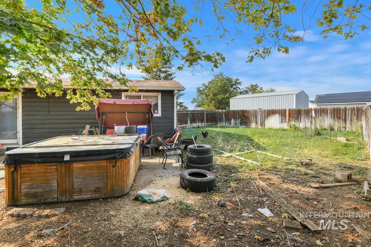 Fenced backyard with a hot tub and a patio
