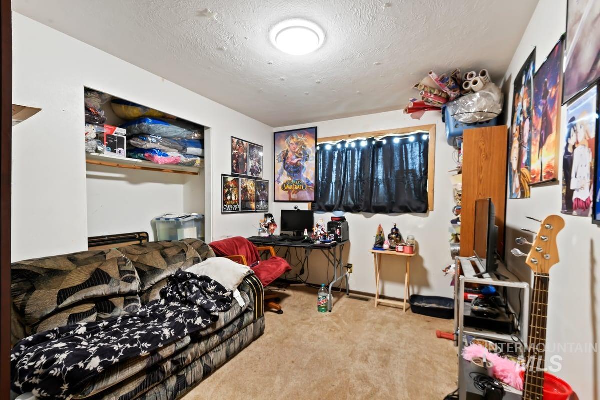 Bedroom featuring a textured ceiling and light carpet