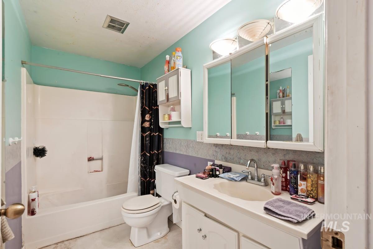 Full bathroom with shower / bath combination with curtain and vanity