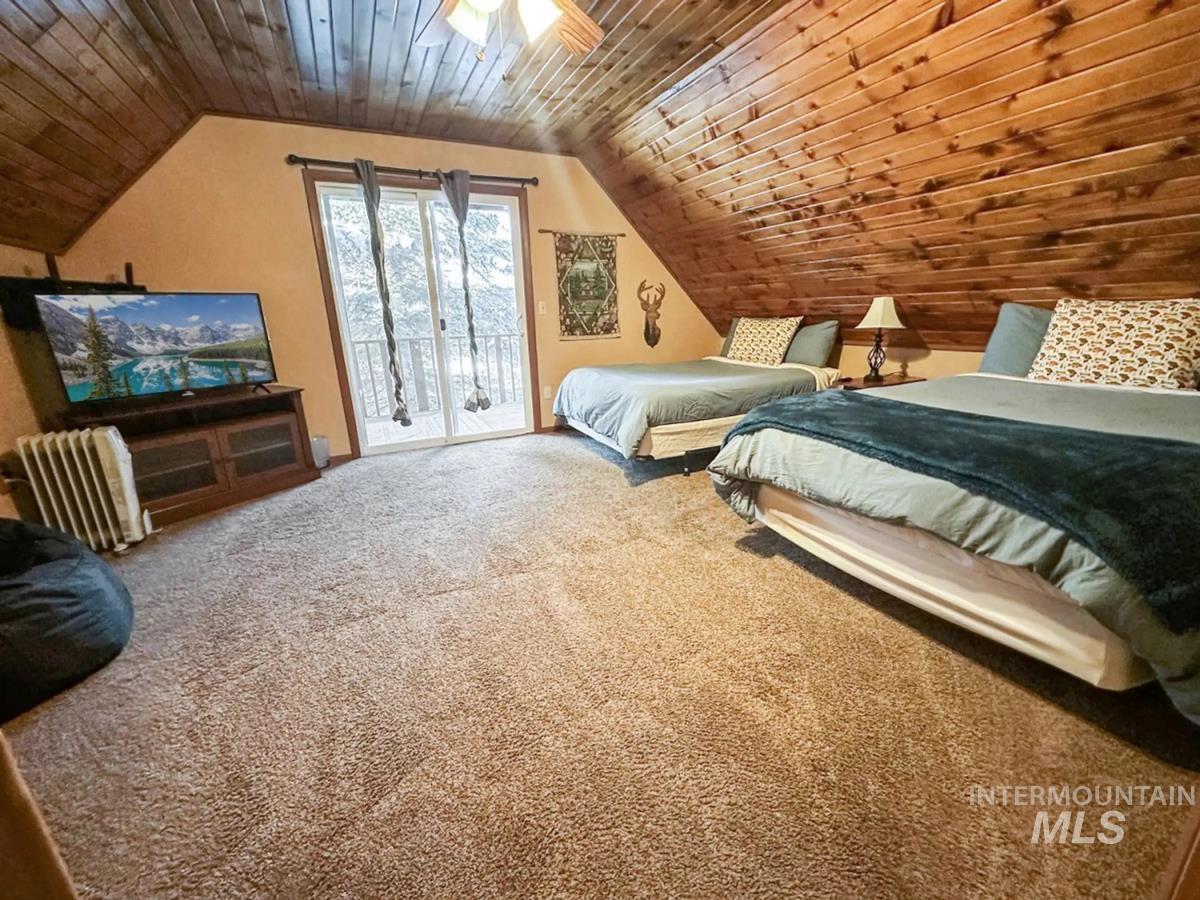 Bedroom with access to outside, carpet floors, lofted ceiling, and wooden ceiling