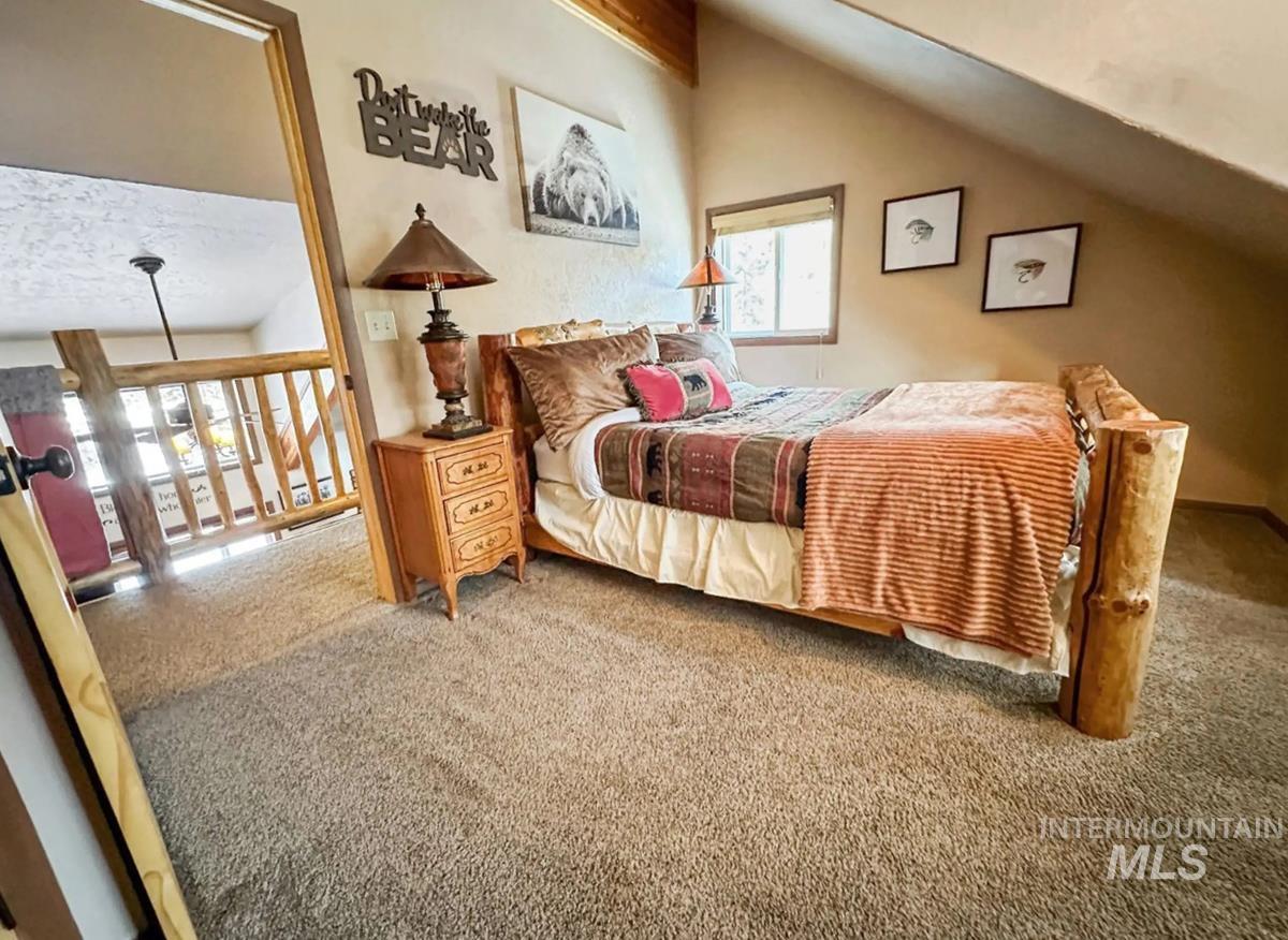Carpeted bedroom featuring vaulted ceiling