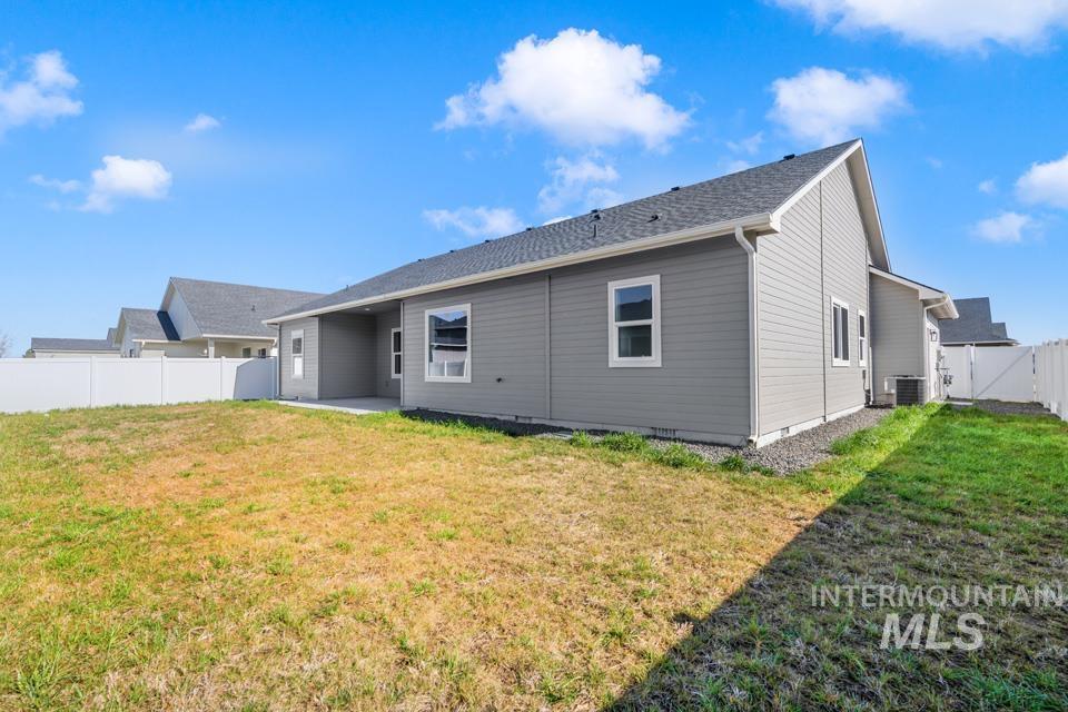 Rear view of house featuring a patio, a fenced backyard, and a gate