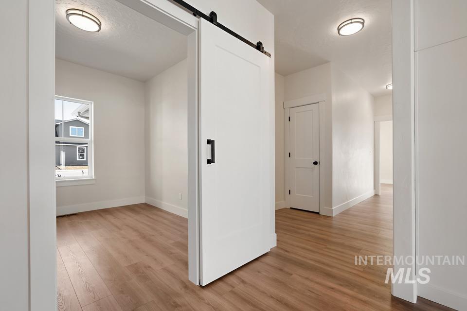 Hallway featuring a barn door and light wood-type flooring