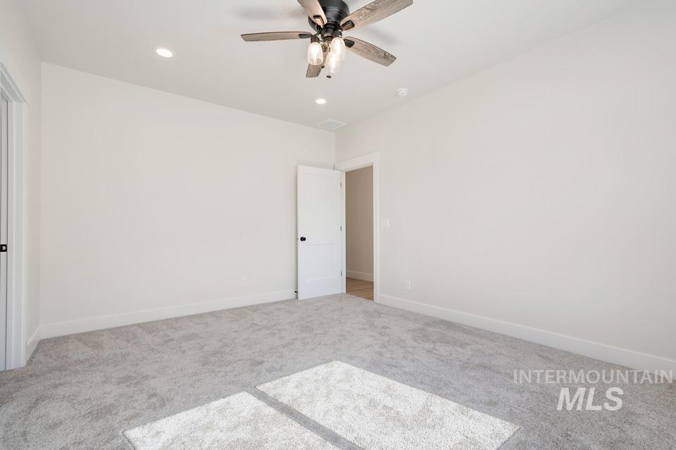 Spare room with light colored carpet, ceiling fan, and recessed lighting