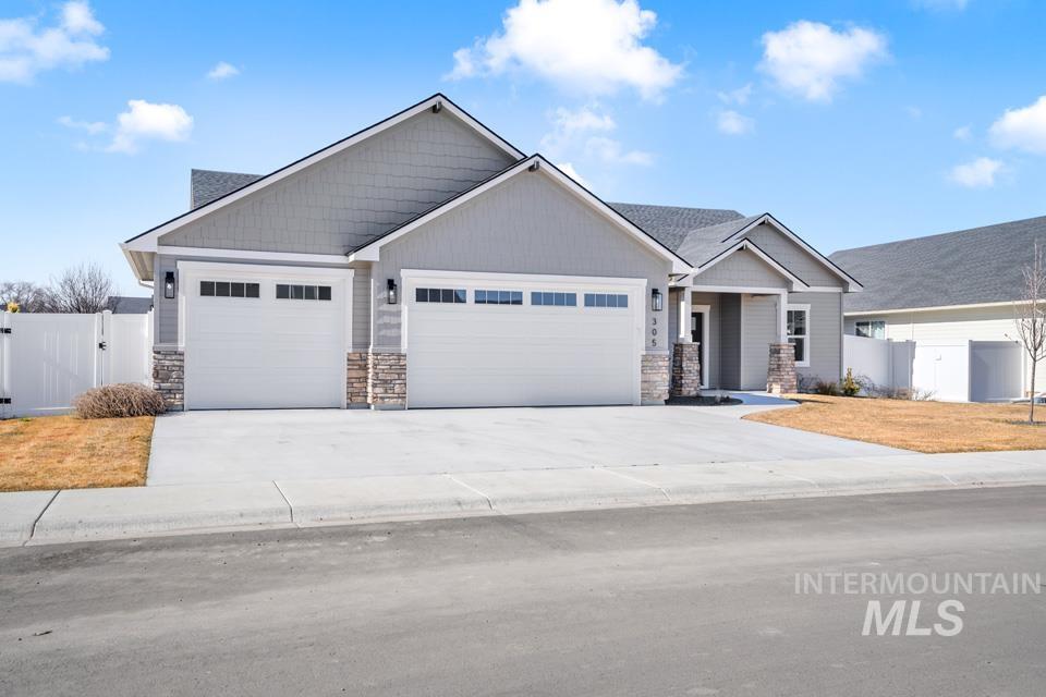 Craftsman inspired home featuring a gate, a garage, concrete driveway, and stone siding