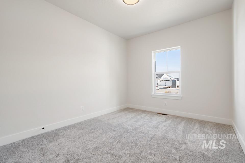 Spare room with light carpet and baseboards