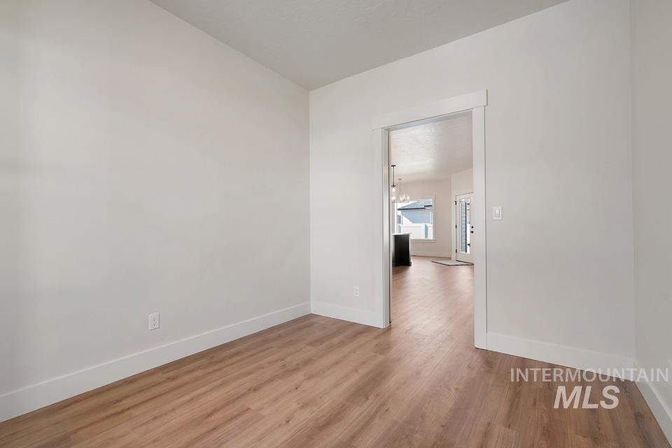 Unfurnished room with light wood-style flooring and baseboards