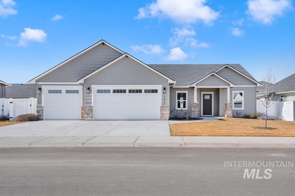 Craftsman-style home featuring stone siding, a gate, an attached garage, and driveway