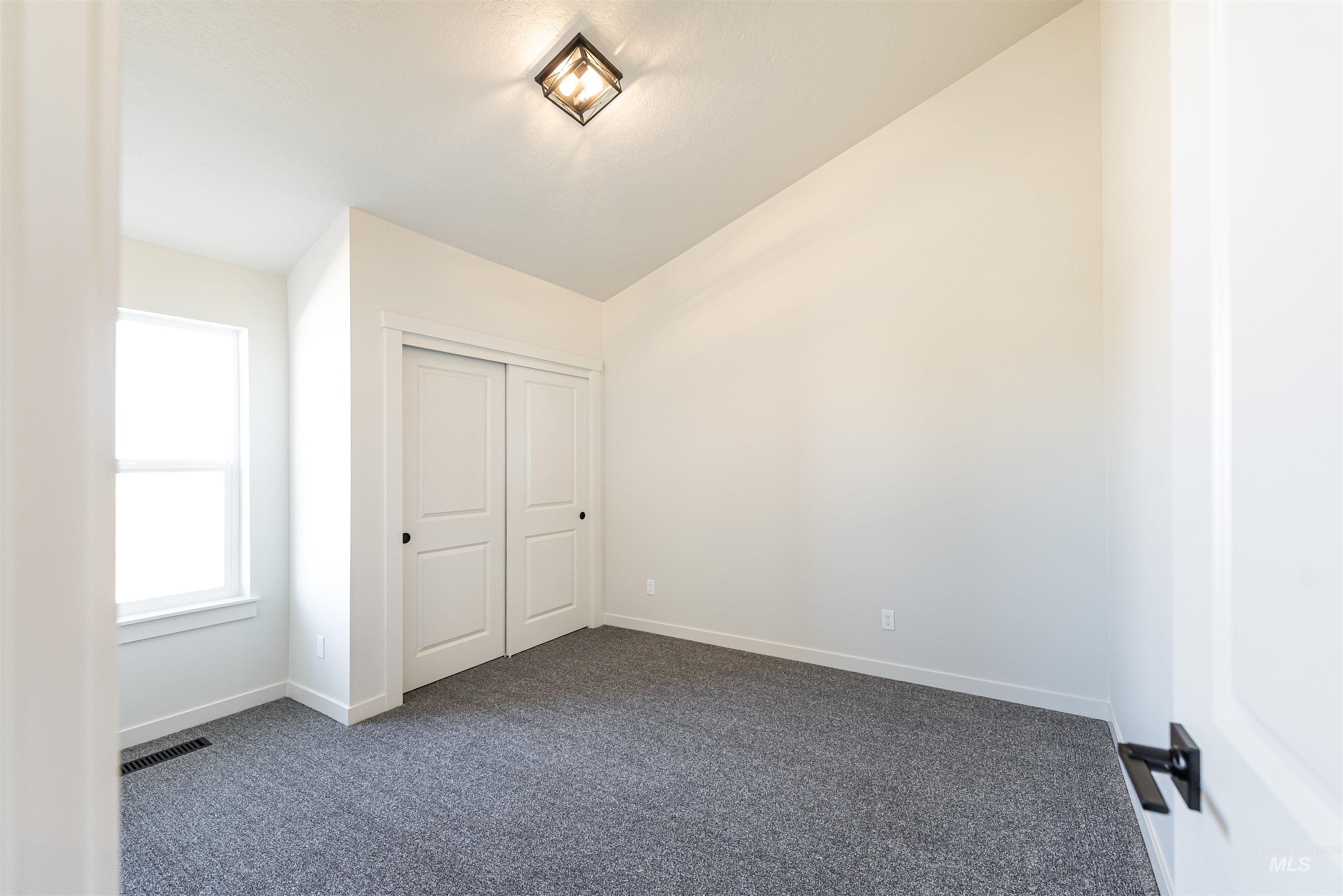 Unfurnished bedroom with dark colored carpet and a closet