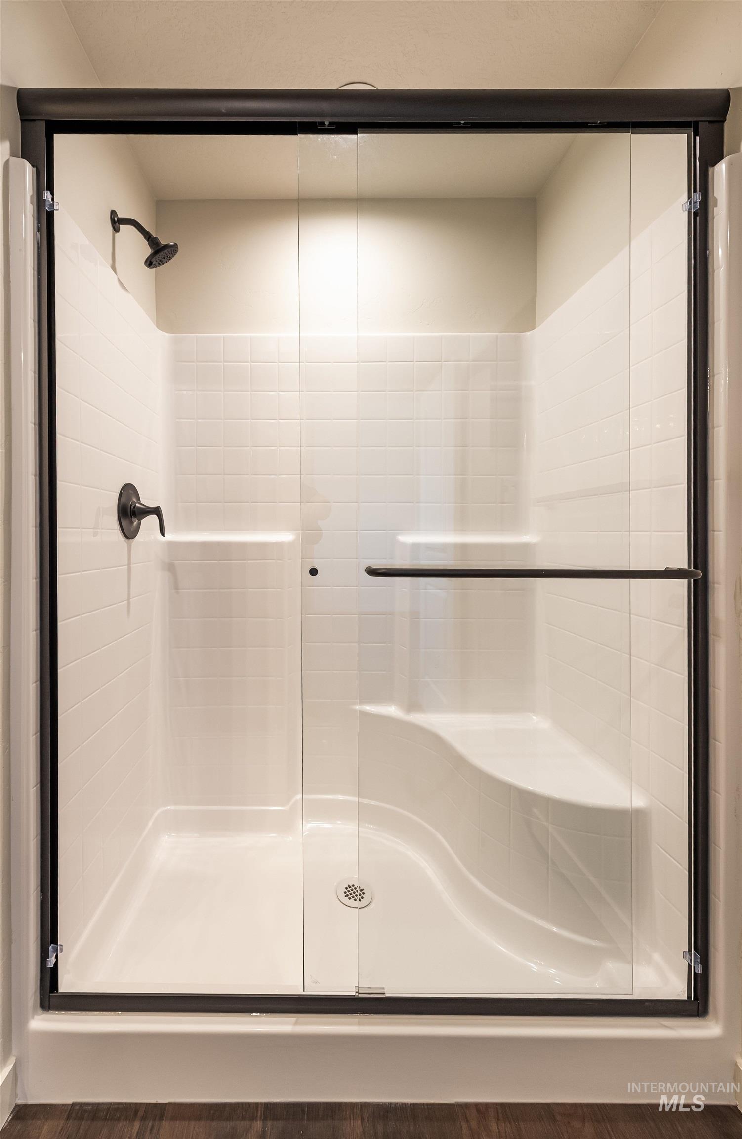 Bathroom featuring a stall shower and wood finished floors