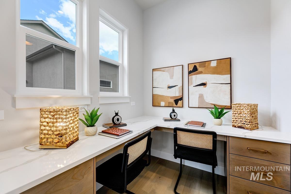 Home office featuring built in desk and wood finished floors