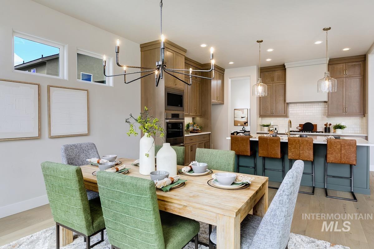 Dining area featuring light wood-style floors, a chandelier, and recessed lighting