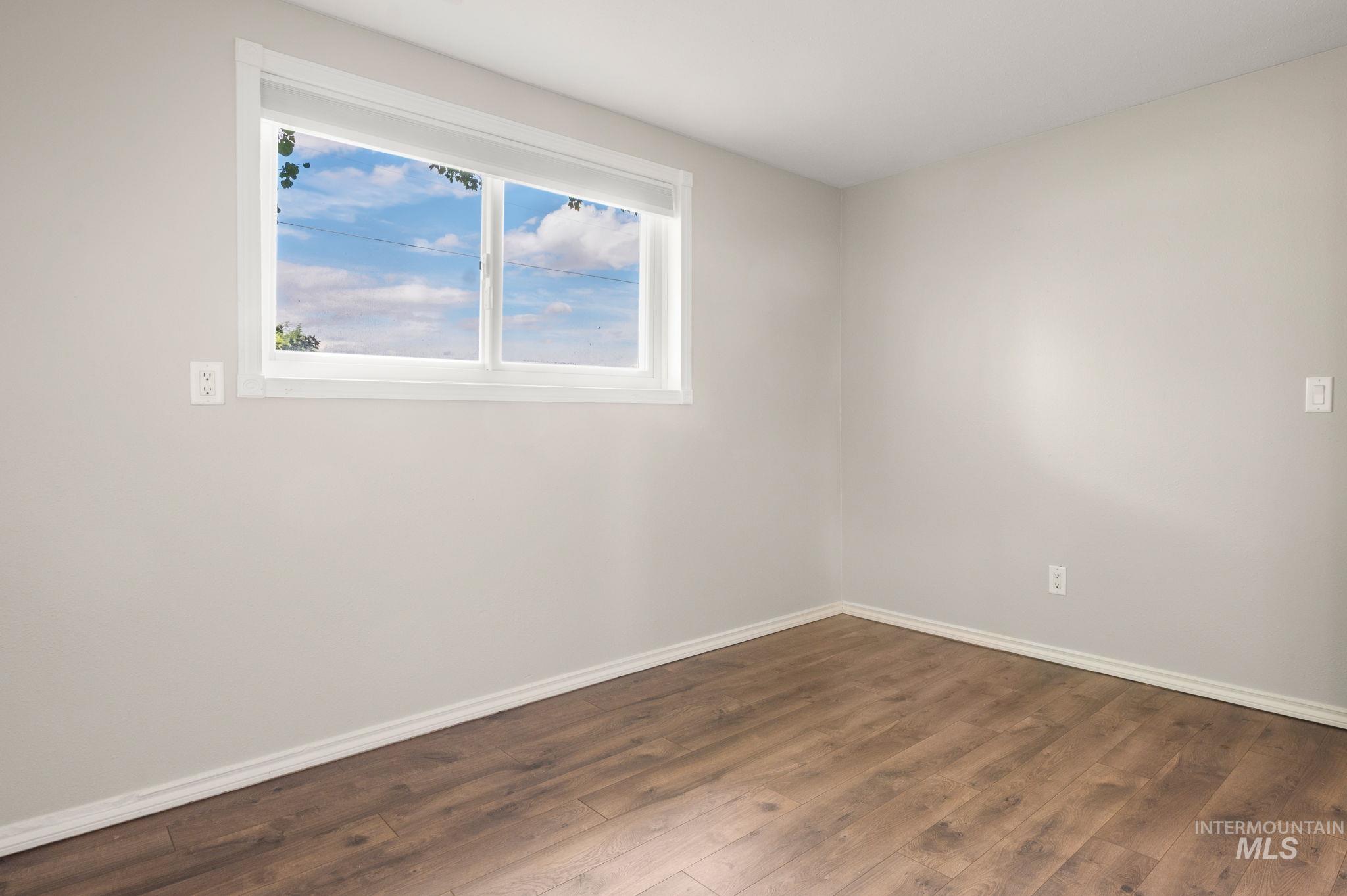 Spare room featuring baseboards and hardwood / wood-style floors