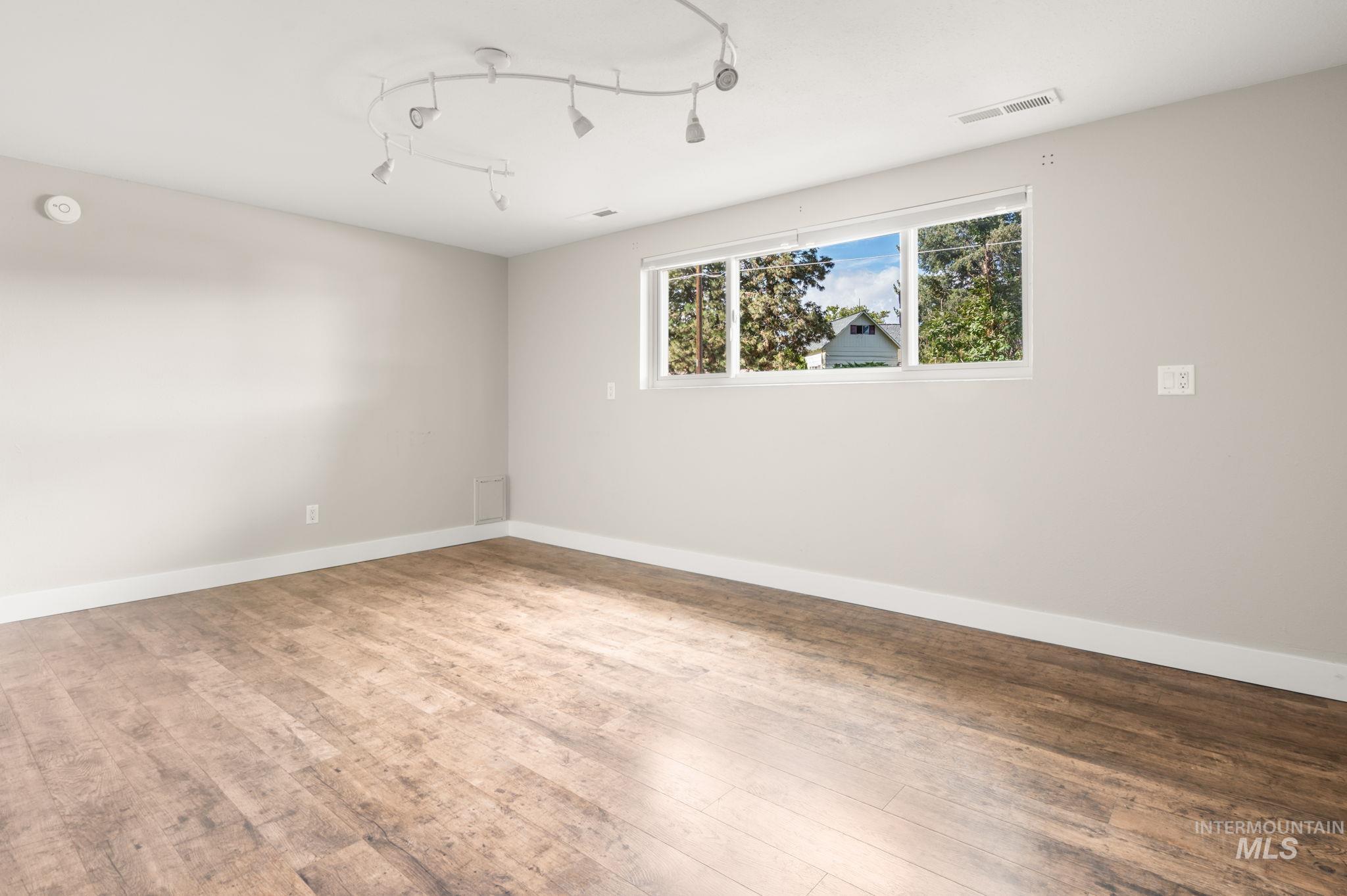 Unfurnished room with baseboards and wood finished floors