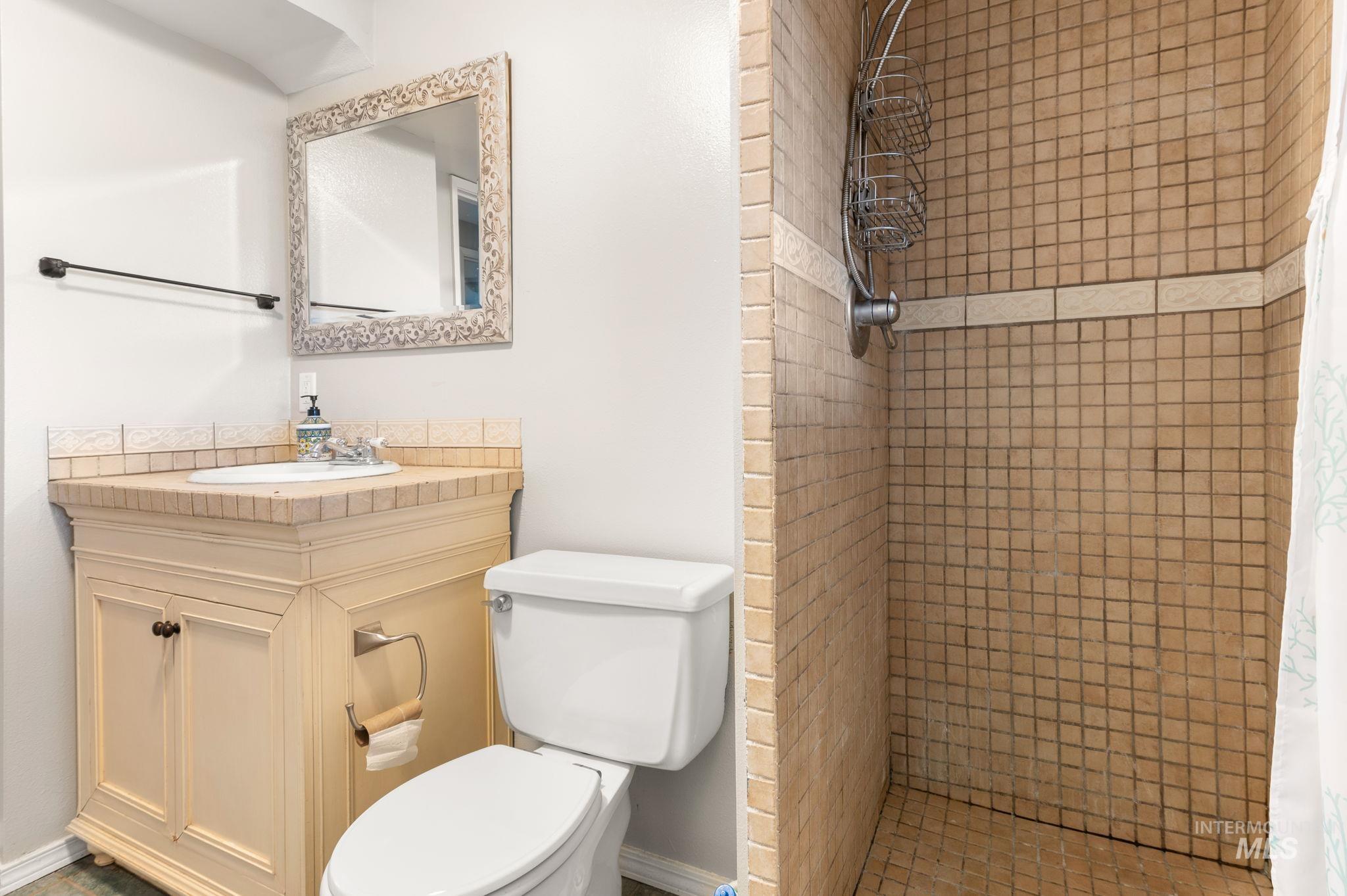 Full bath featuring a shower stall and vanity