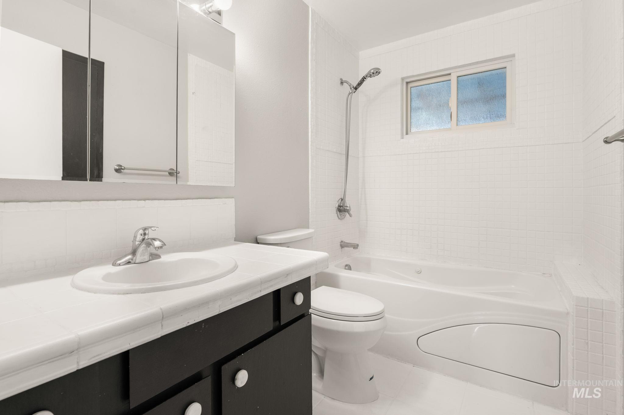 Full bath with  shower combination, vanity, and tile patterned flooring