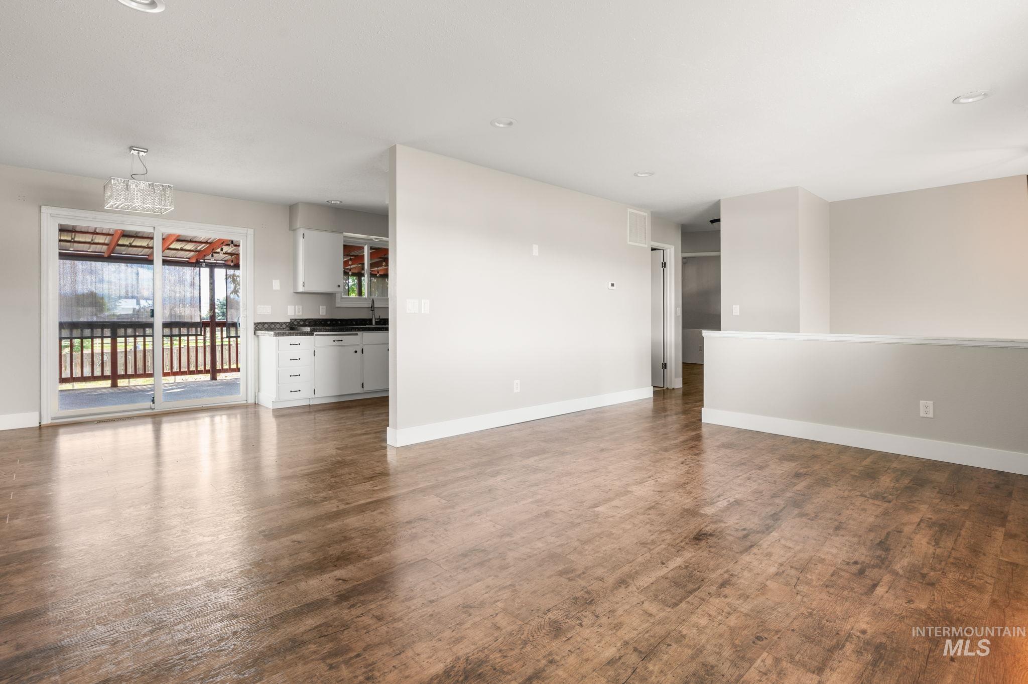 Unfurnished living room with recessed lighting and dark wood-style flooring