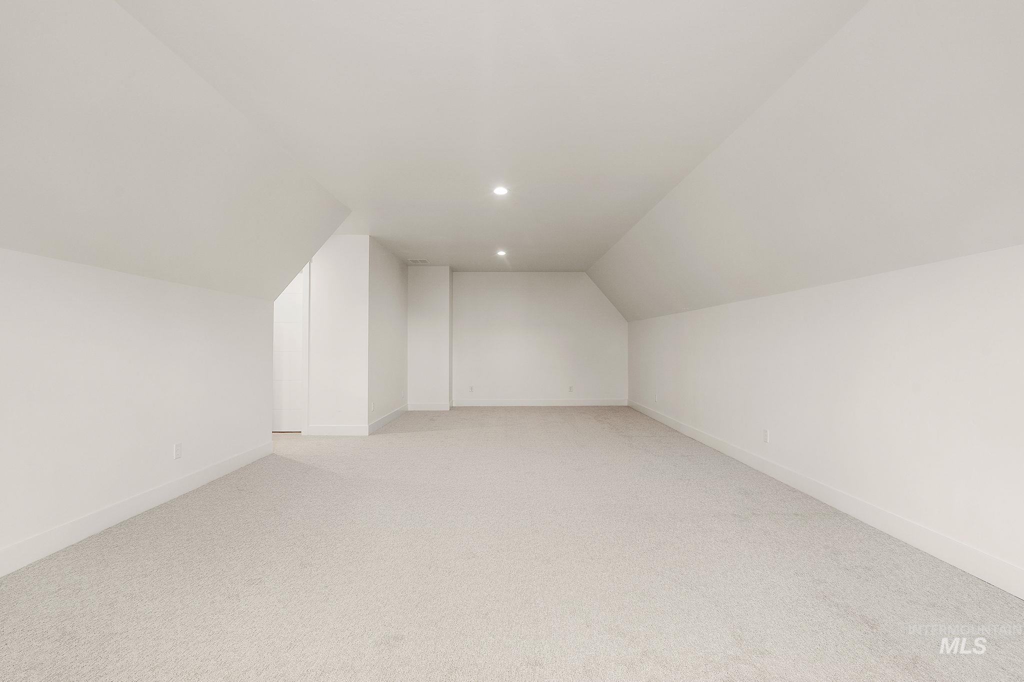 Bonus room with lofted ceiling, light colored carpet, and recessed lighting