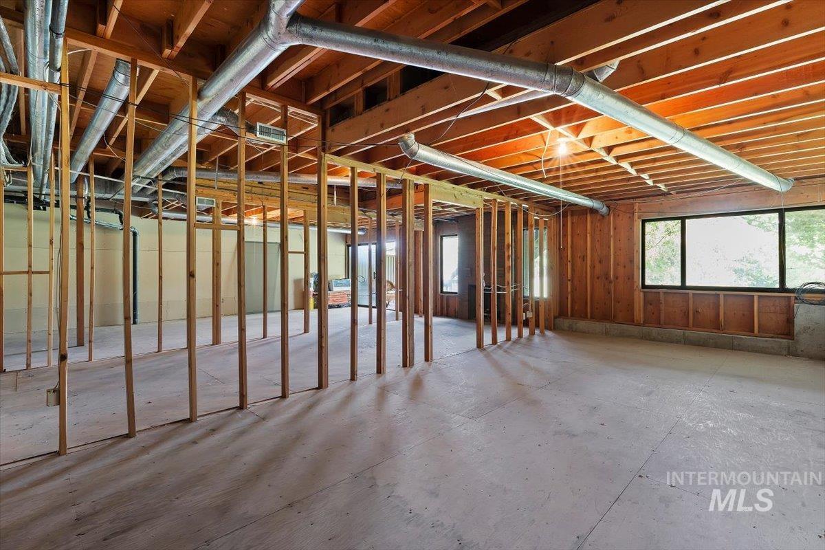 Unfinished interior space with exposed wood framing, concrete flooring, and visible ductwork