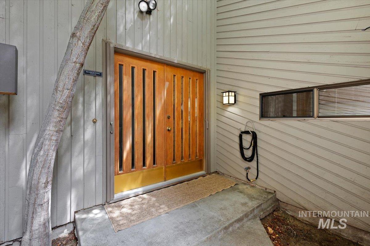 Warm wood double entry doors with vertical lites and brass kick plates