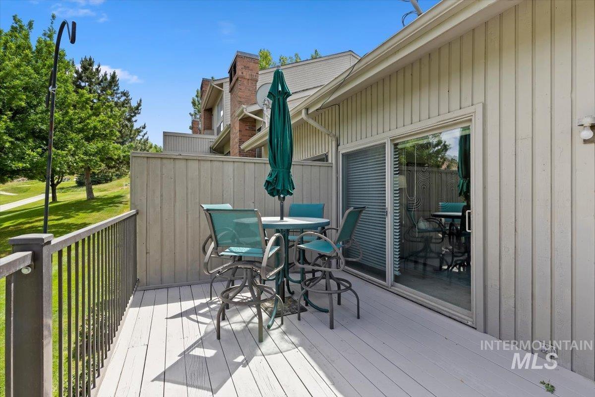 Spacious outdoor deck featuring light-colored decking, a privacy wall, and a sliding glass door
