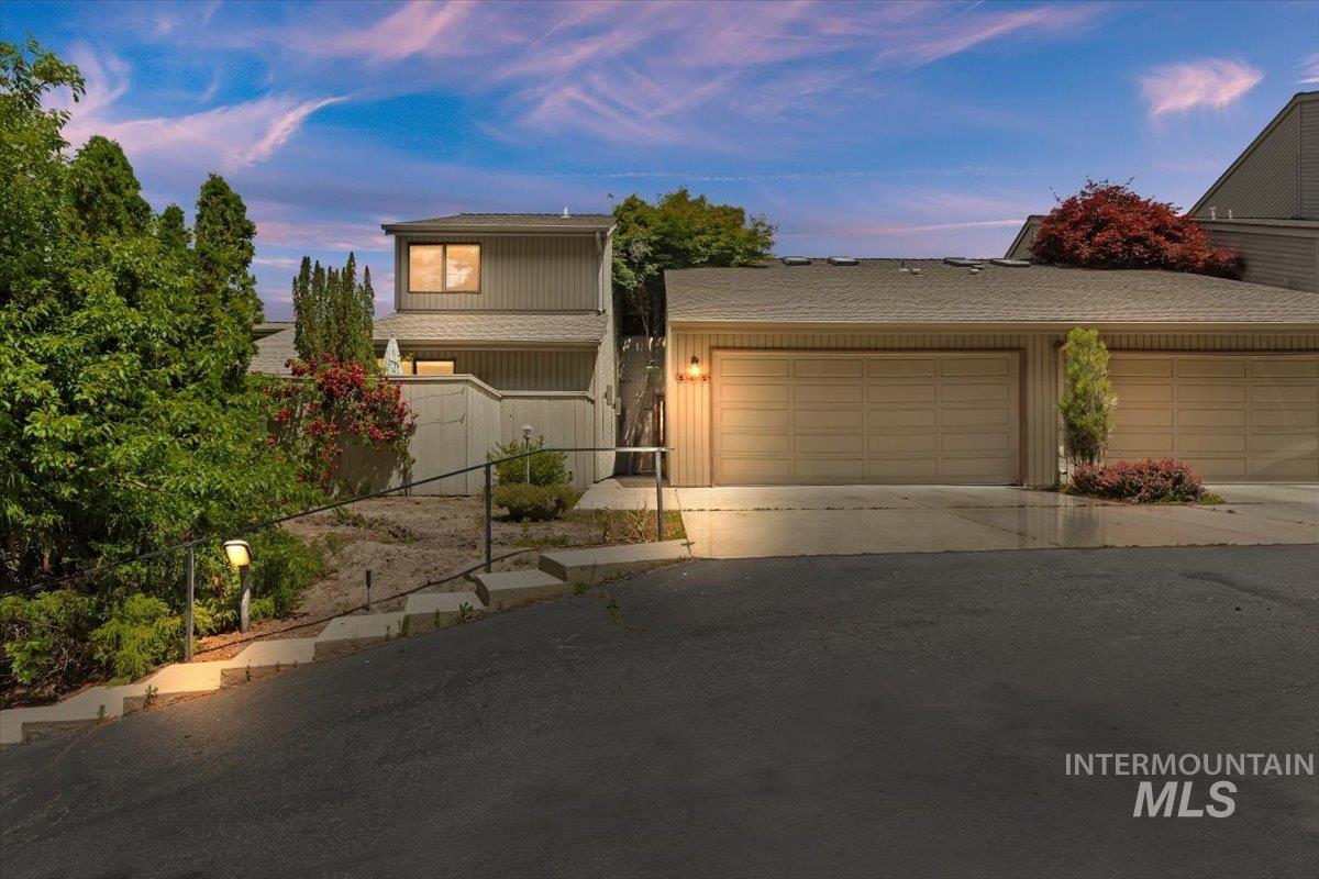 Integrated two-car garage with overhead lighting and a paved driveway