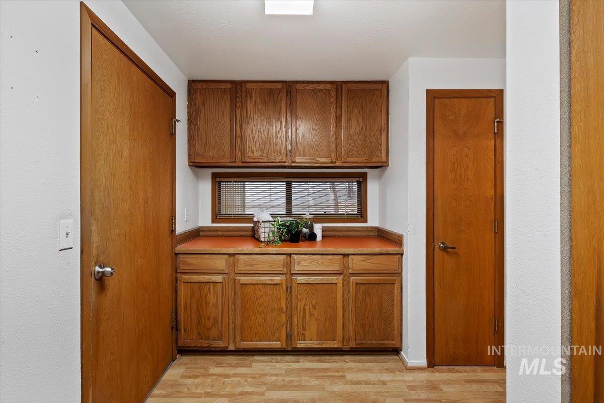 Utility area with wood-finish flooring and integrated cabinetry