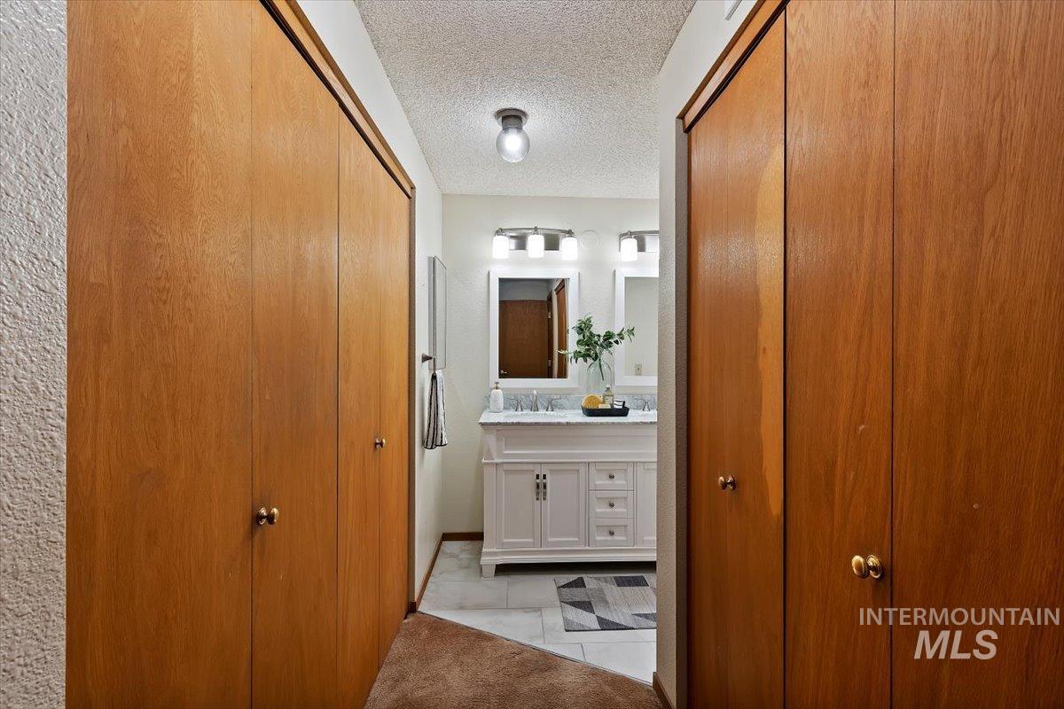 Double vanity with white cabinetry and a light-toned countertop