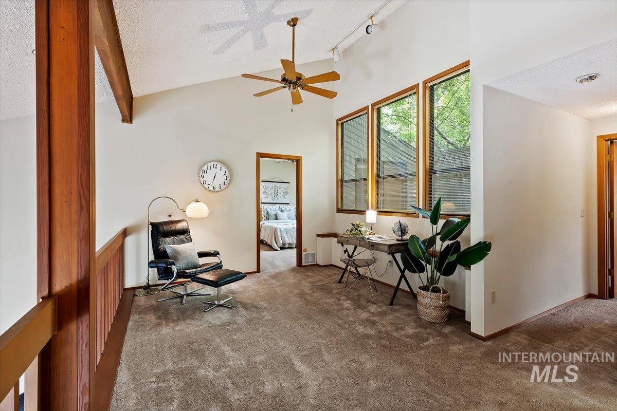 Vaulted ceiling with exposed wood beam and a ceiling fan
