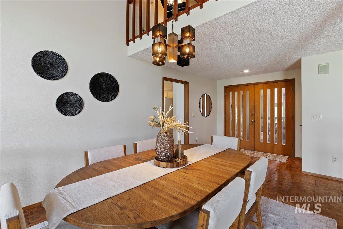 Dining area featuring a prominent wood-finish dining table and a contemporary multi-bulb chandelier